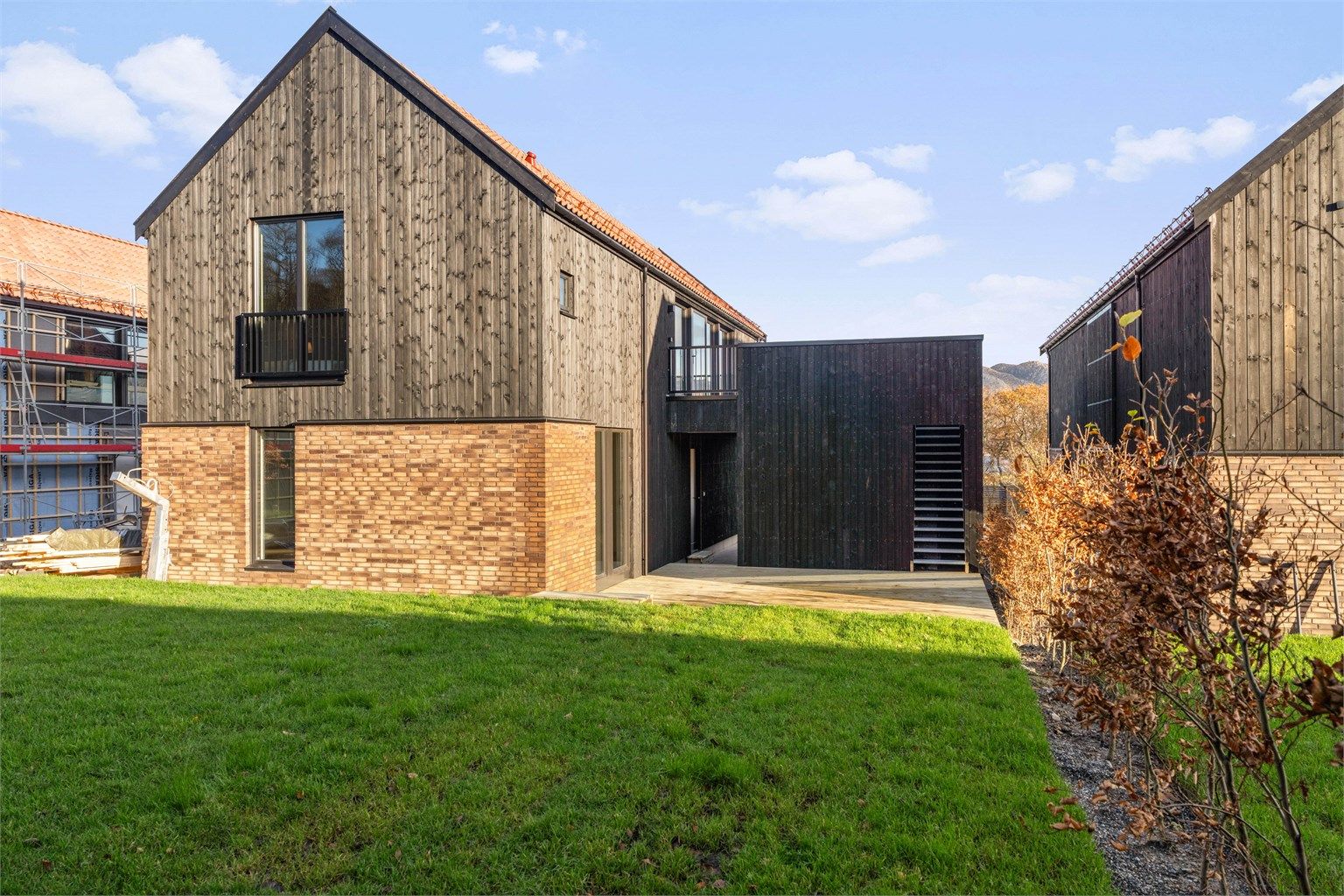 Boligen har et pent materialvalg, med teglstein, stående kledning, store vindusareal m.m. Eiendommen har en ca. 50 kvm markterrasse, romslig hageareal, og en ca. 35 kvm takterrasse oppe carport. 
Foto:  Nordbø Foto ved Martin Nordbø.