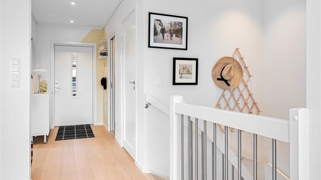 Lys entré med enstavs eikeparkett lagt i 2024 og downlights i taket.