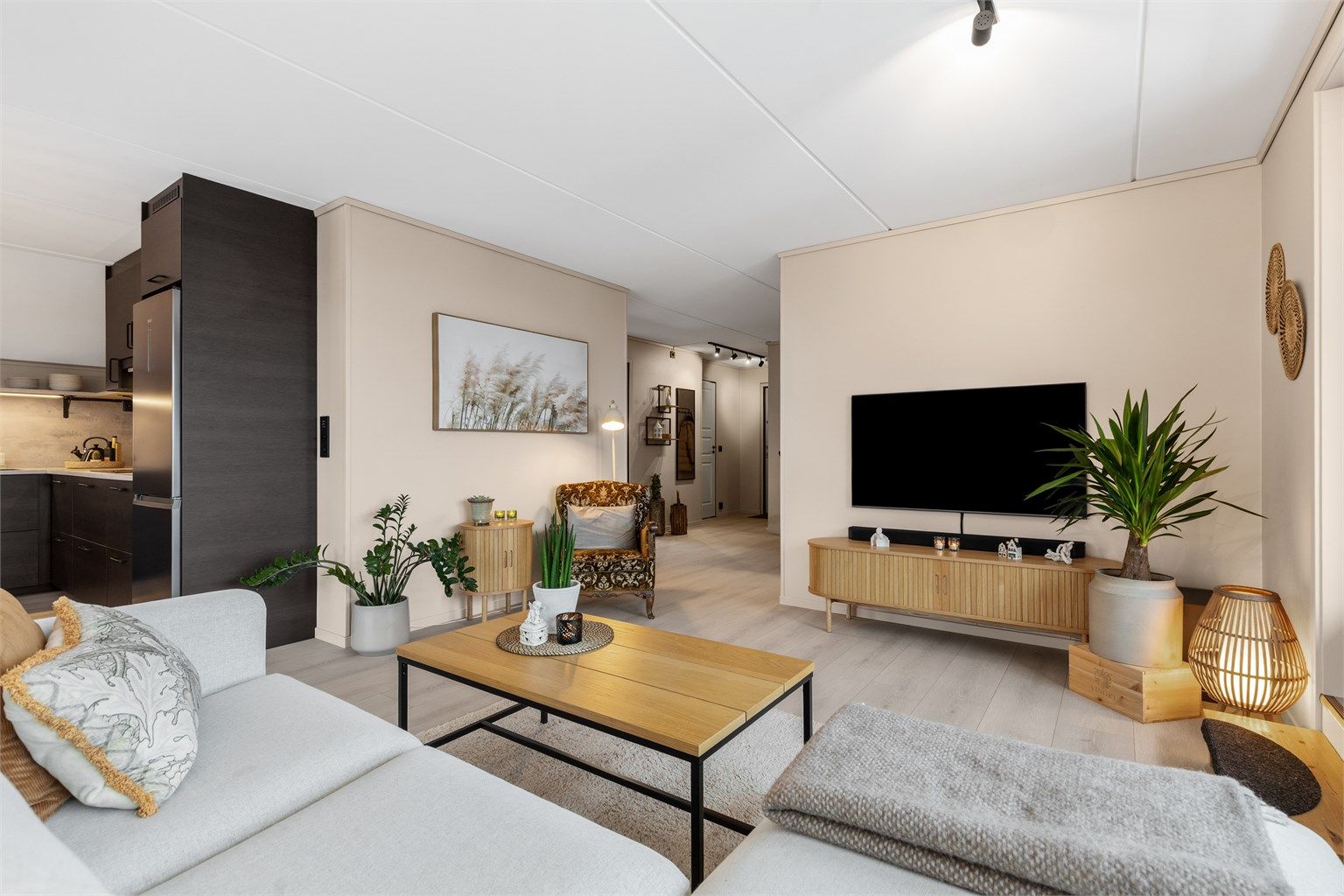 Den åpne løsningen mellom stue og kjøkken skaper en sosial og luftig atmosfære.