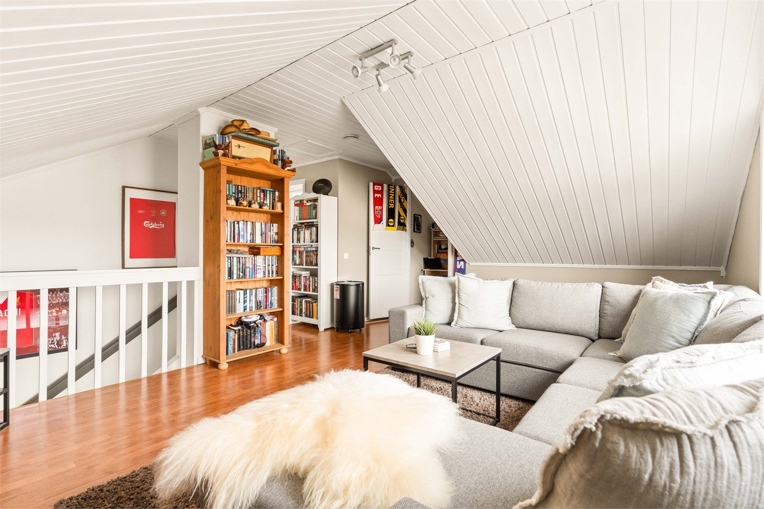 Trappen leder opp til en hyggelig loftstue med panel i himlingen.