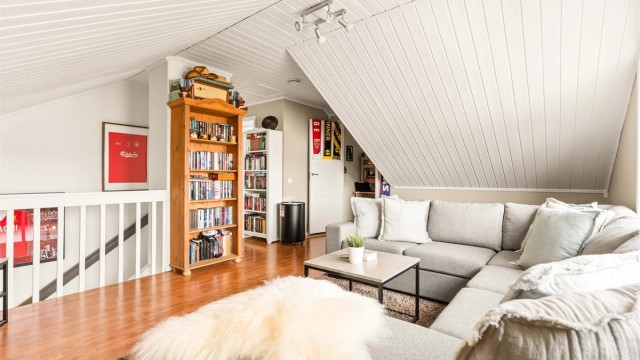 Trappen leder opp til en hyggelig loftstue med panel i himlingen.