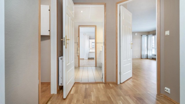 Gangen med ny parkett på gulv fra 2025.
Hvite profileret innerdører.
