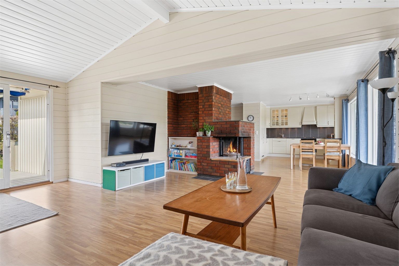 Den gode takhøyden og den fine åpne peisen setter et fint preg på rommet.