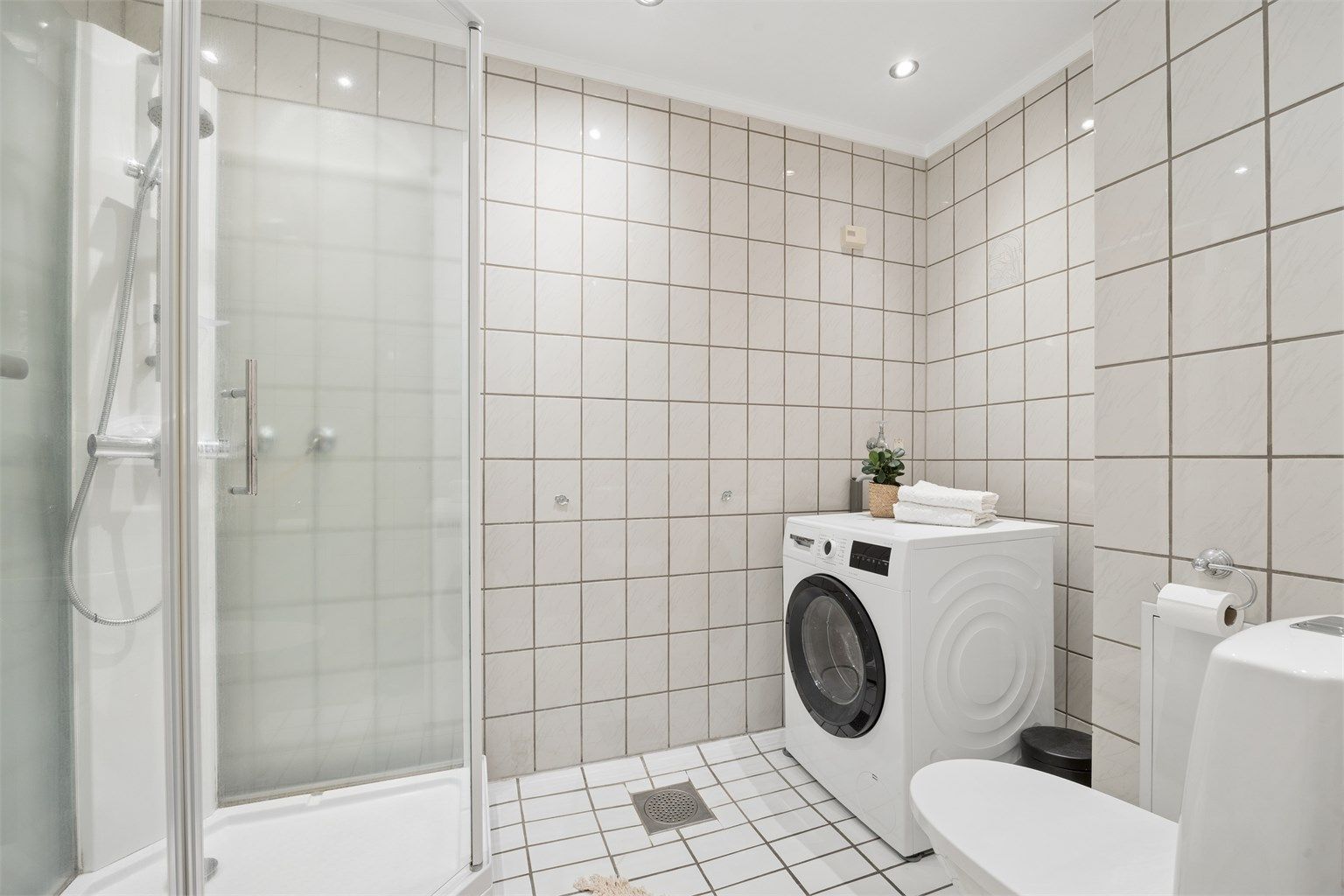 Badet er praktisk innredet med downlights i tak og opplegg for vaskemaskin.