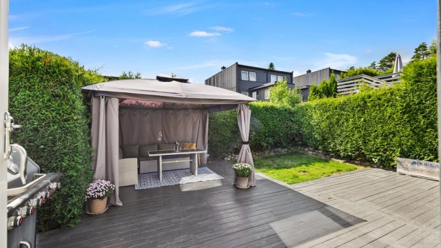 Uteplassen er skjermet med en romslig terrasse og hage, med god plass til utemøbler.