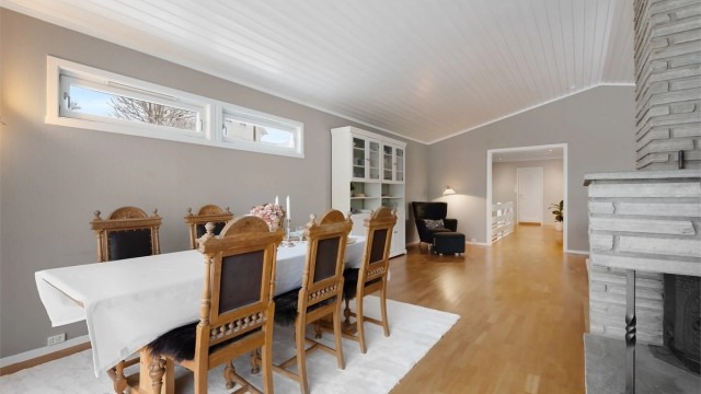 Den åpne løsningen mellom stue og spisestue skaper en sosial og innbydende sone.