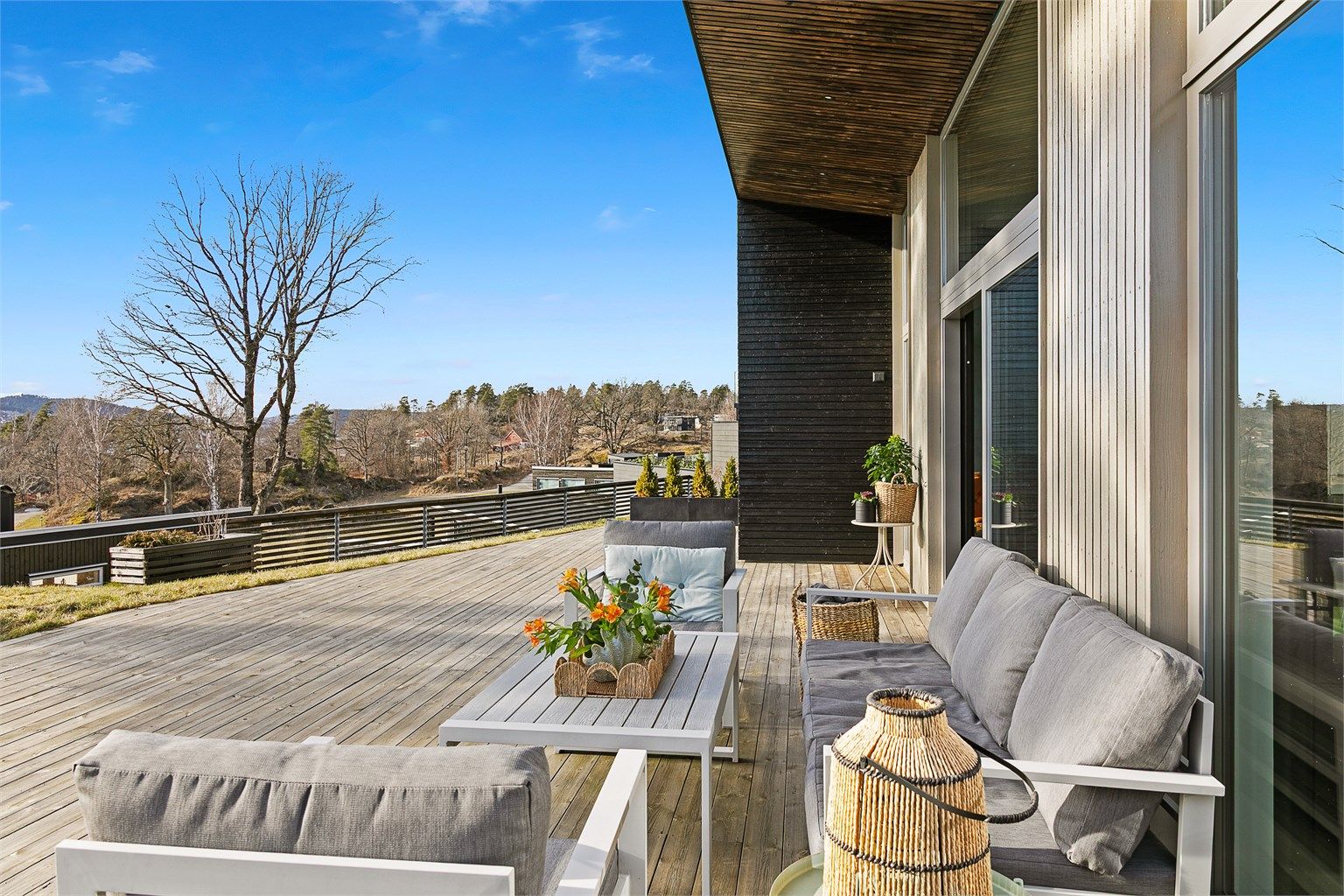 Stor skyvedør i glass fra stue og kjøkken fører ut på terrassen.