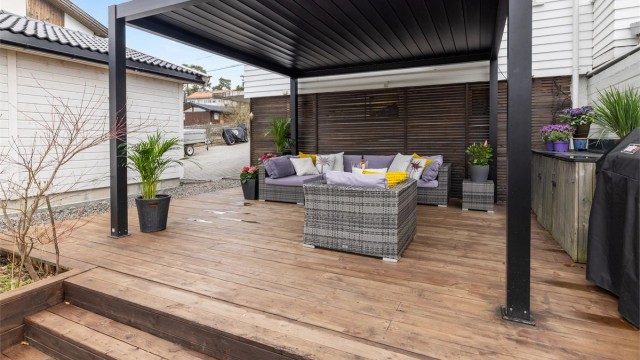 En nyere pergola skaper en lun og definert sone i hagen, perfekt for sosiale sammenkomster.