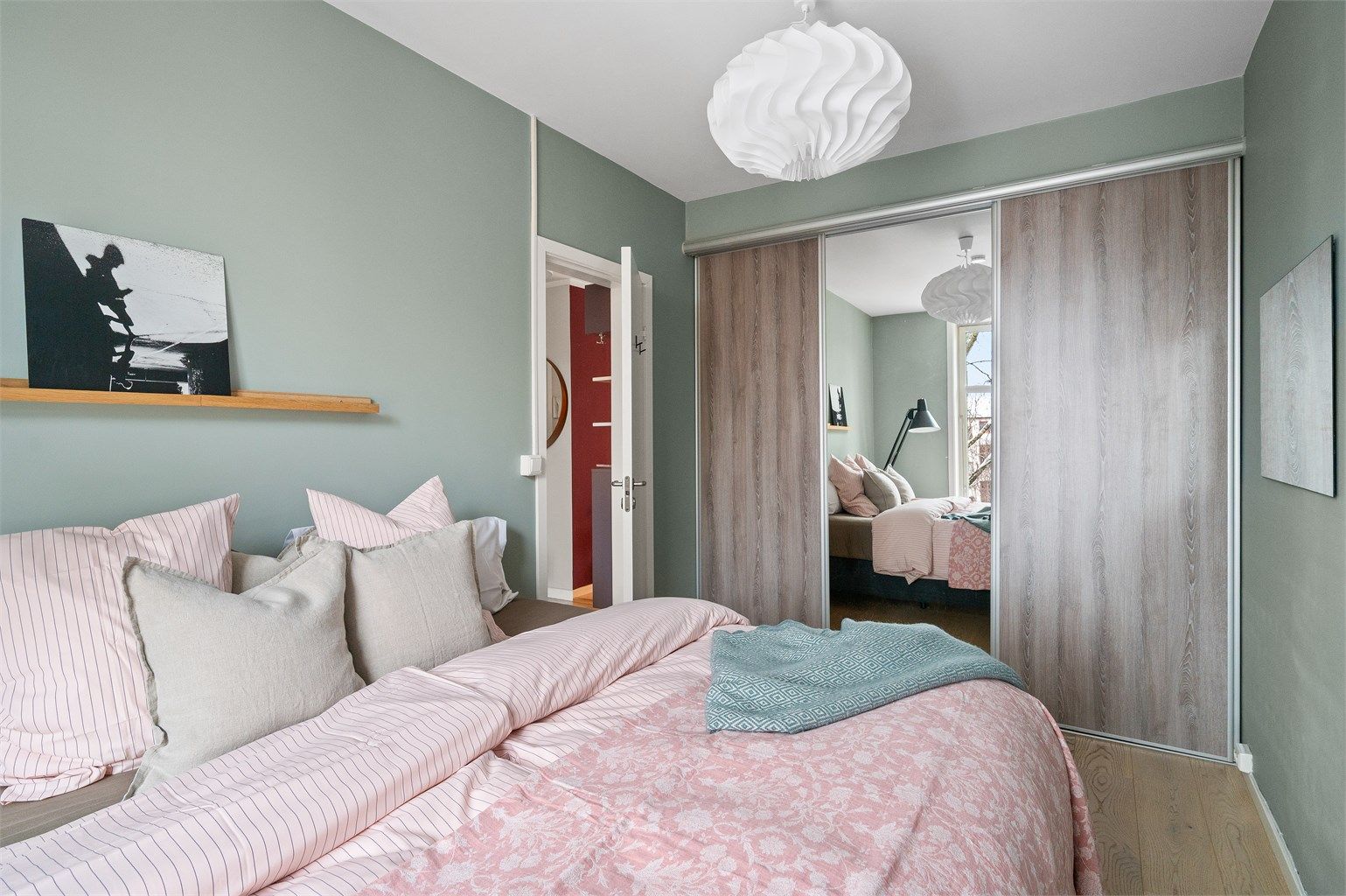 En stor skyvedørsgarderobe med fleksibelt hyllesystem gir rikelig med oppbevaringsplass.