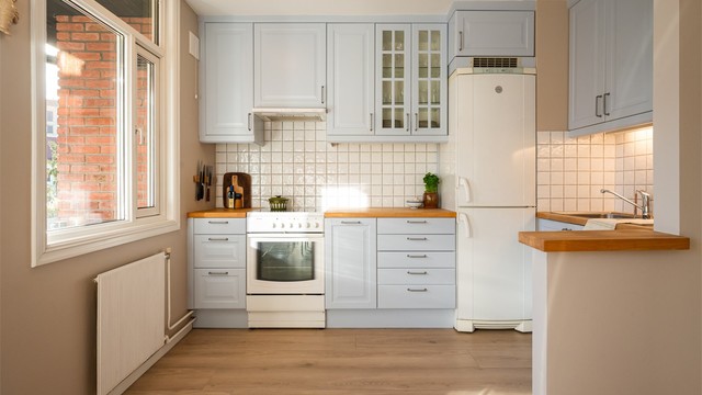 Kjøkkenet har profilerte fronter som ble malt i 2024, benkeplate i tre og nedfelt kjøkkenvask med armatur.