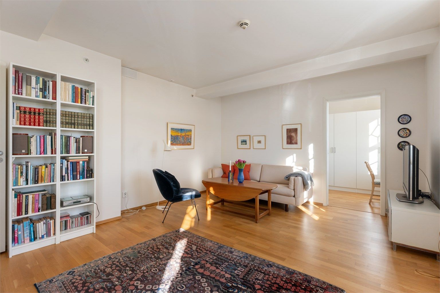 Gjennomgående parkett på gulv og malte, lyse flater danner et nøytralt utgangspunkt.