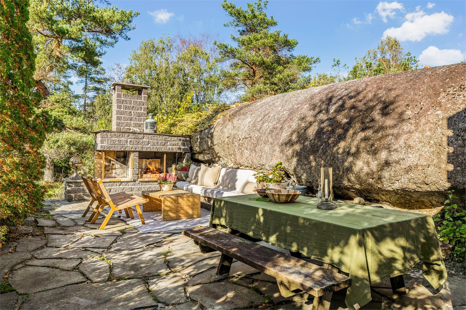 En herlig uteplass med peis hvor naturen danner en naturlig avgrensning.