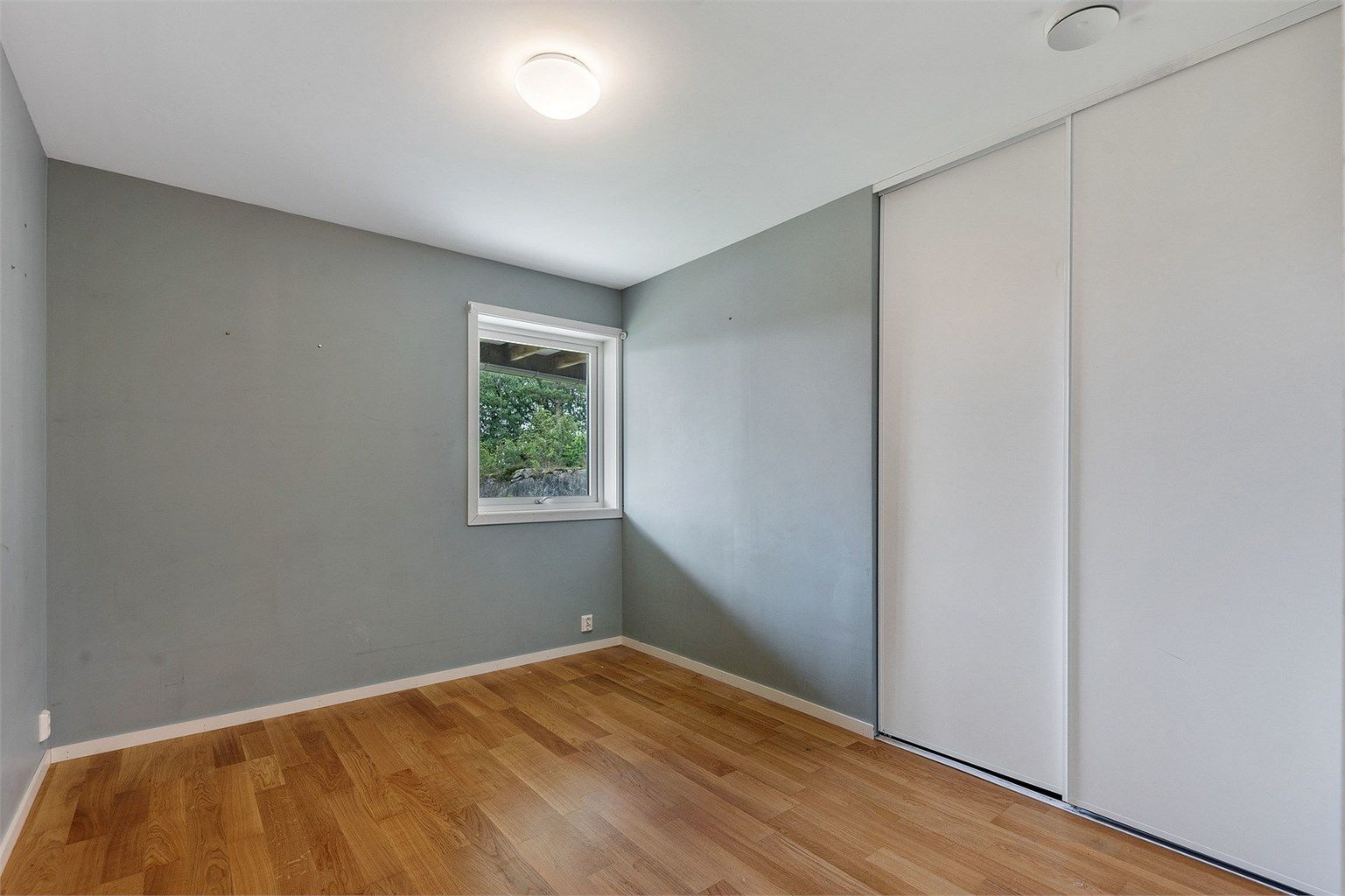 Boligens tredje soverom i første etasje, med plass til seng og skyvedørsgarderobe.