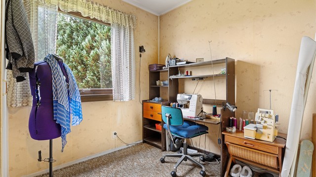 Soverom med teppe på gulv og tapet på vegger
