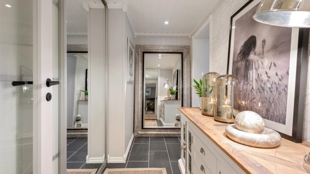 Fra gangen er det skyvedørsfronter inn til et praktisk garderoberom/bod