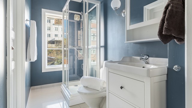 Badet er utstyrt med dusjkabinett, servant med underskap og toalett.