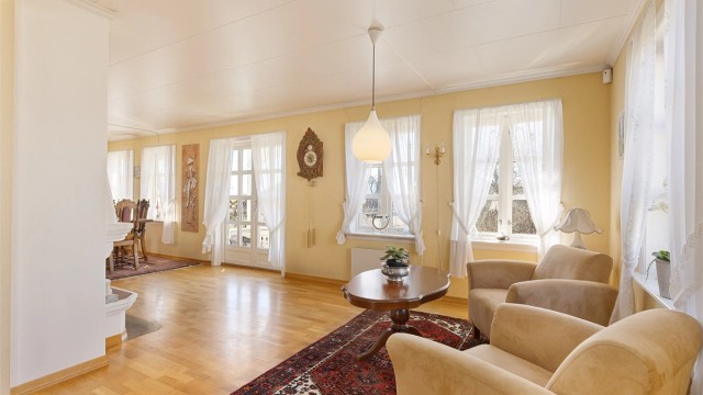 Det er også plass til et par loungestoler ved den koselige peisen