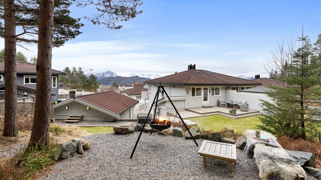 Tomten er opparbeidet med grus, plenarealer og diverse beplantninger - koselig uteplass i skogen like utenfor tomtegrense med bålplass (friareal)