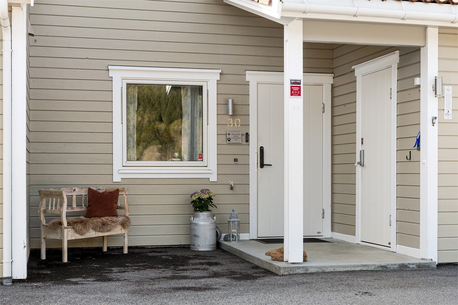 Overbygd inngangsparti med sportsbod og elektrisk kodelås på ytterdøren.