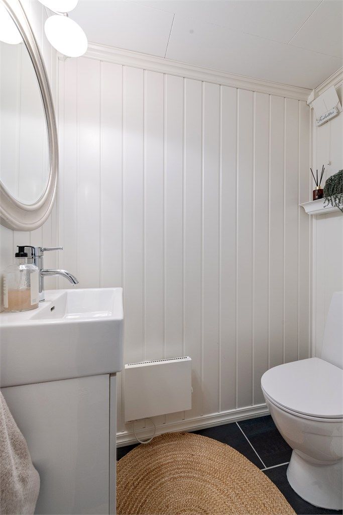 Praktisk toalettrom i underetasjen med flislagt gulv og servantinnredning