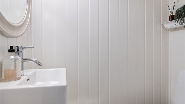 Praktisk toalettrom i underetasjen med flislagt gulv og servantinnredning