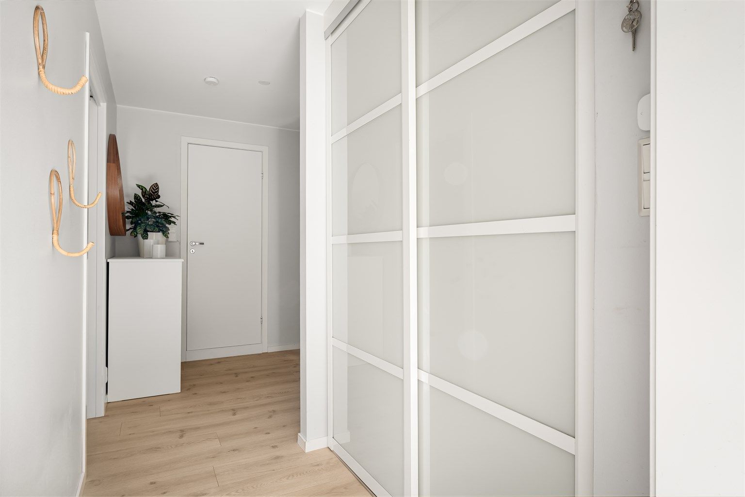 Entré med plassbygget garderobe med skyvedører.