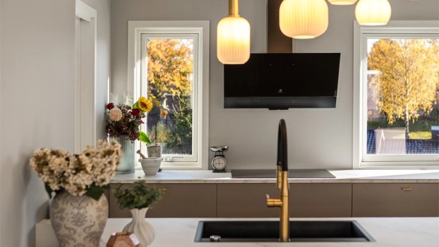 Kjøkkenbenken er plassert under vindusflatene med utsyn mot hagen.