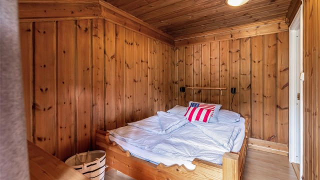 Soverom med trepanel på vegger og i himling.