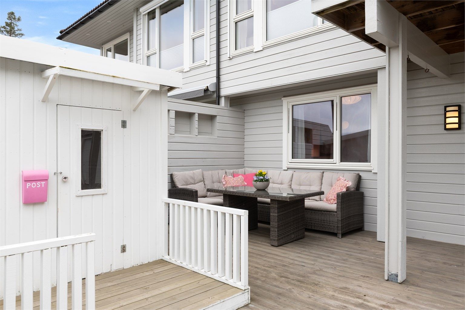 Terrassen er delvis overbygget, noe som gir en lun og skjermet uteplass.