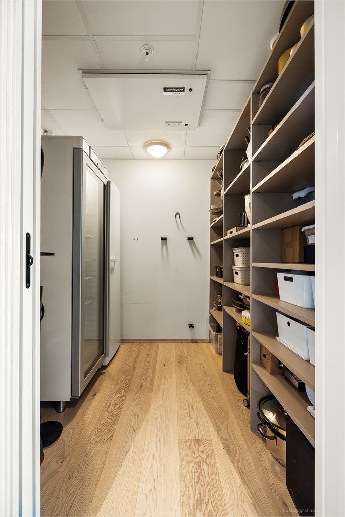 Praktisk innvendig bod med god hylleplass og boligens ventilasjonsaggregat.