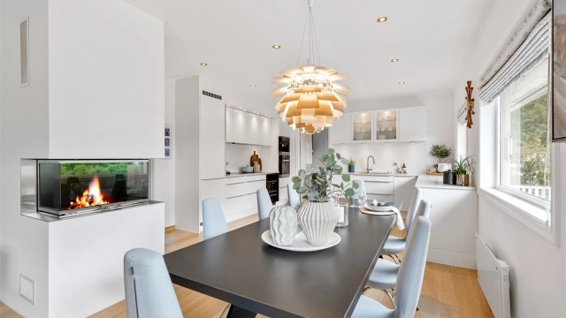 Det er god plass til romslig spisestue i tlknytning til kjøkkenet. Flott og moderne peis med glassdør som kan sees fra både kjøkken og stue
