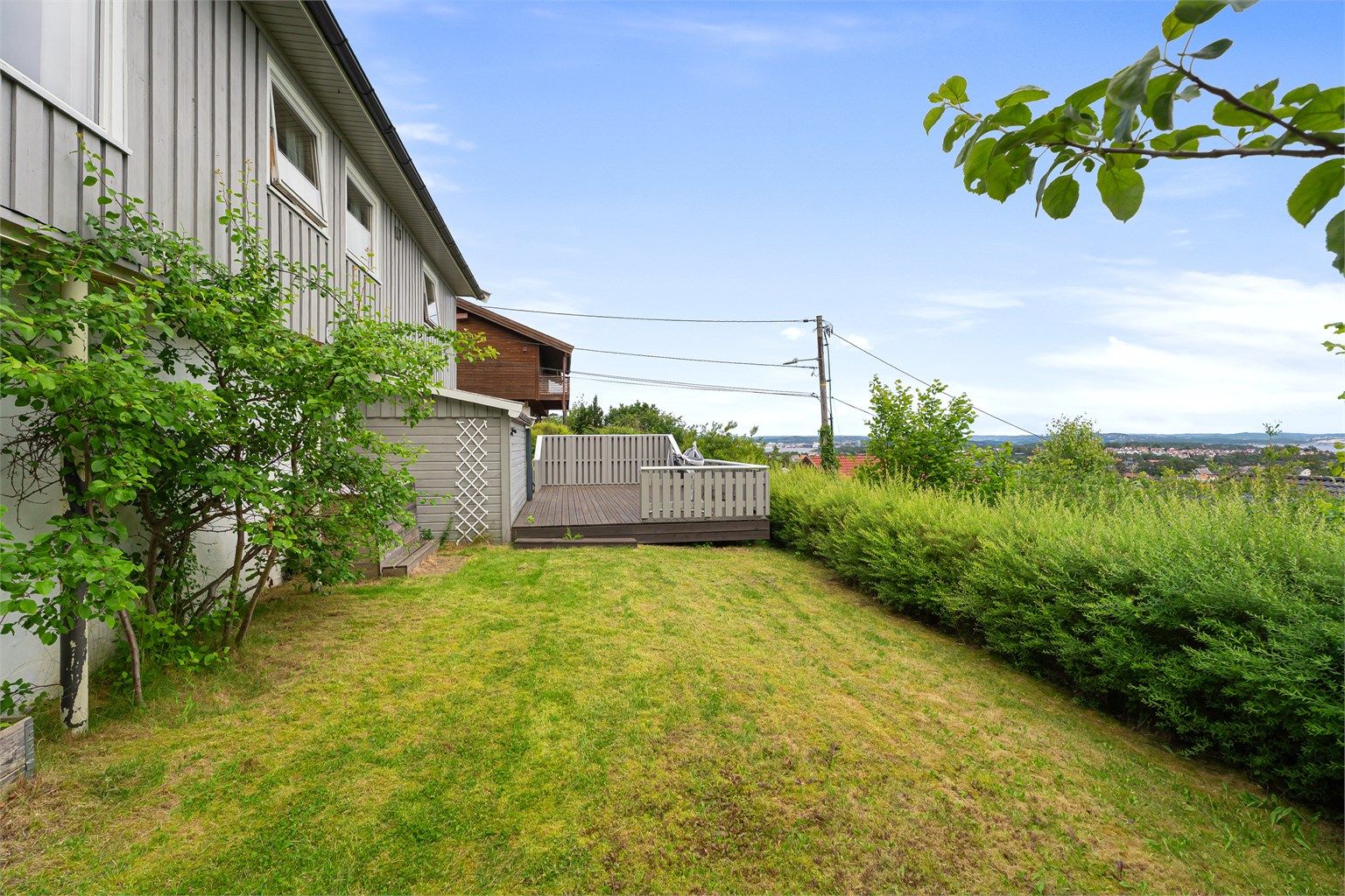 Stor hage med terrasse, gressplen og gode sol- og utsiktsforhold.