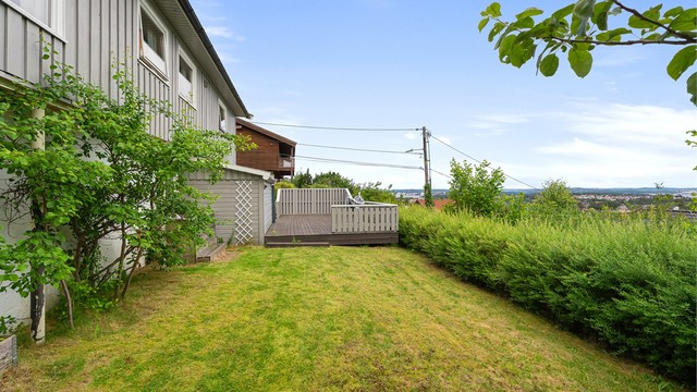 Stor hage med terrasse, gressplen og gode sol- og utsiktsforhold.
