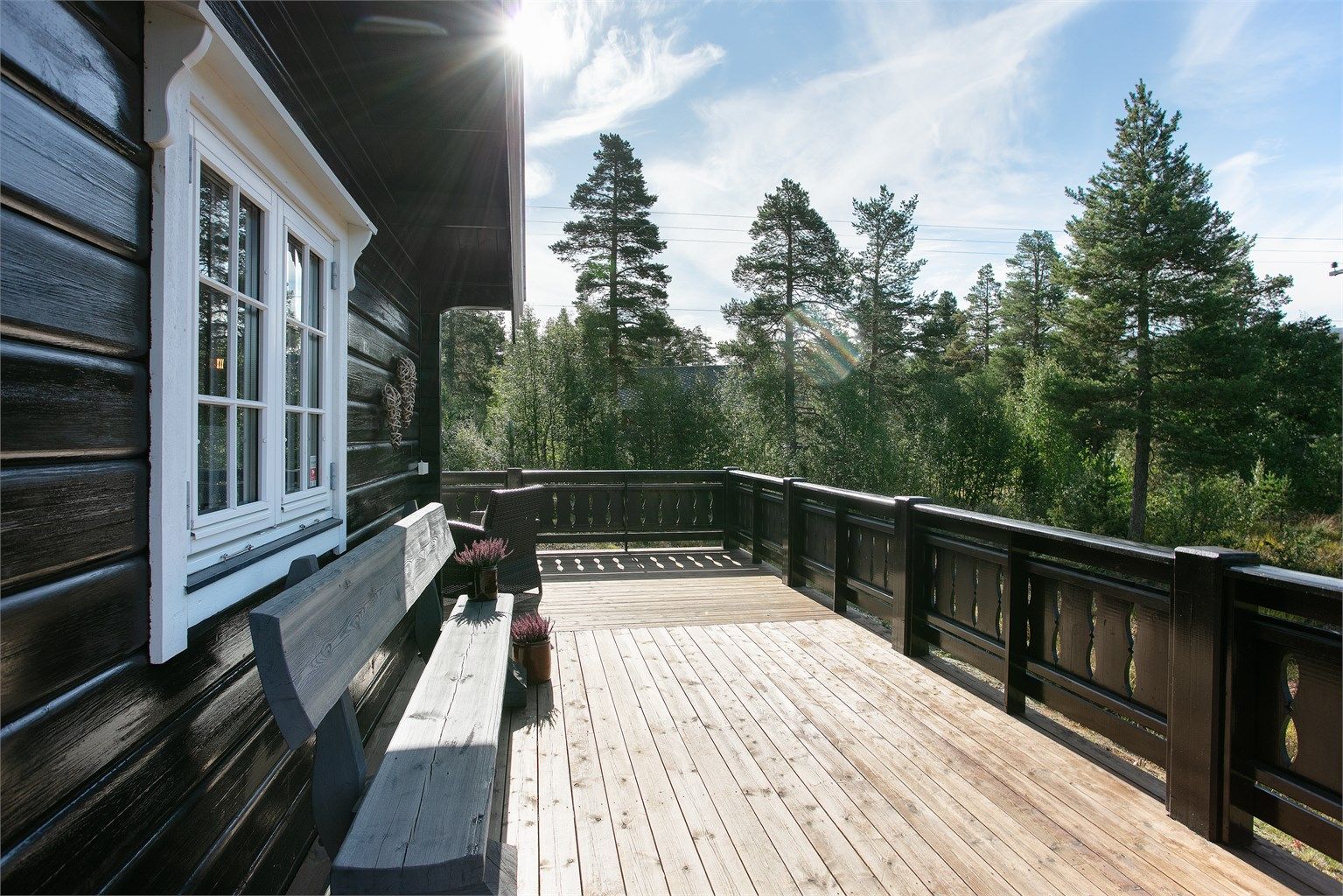 Terrassebord og kraftig rekkverk i tre omkranser uteplassen.