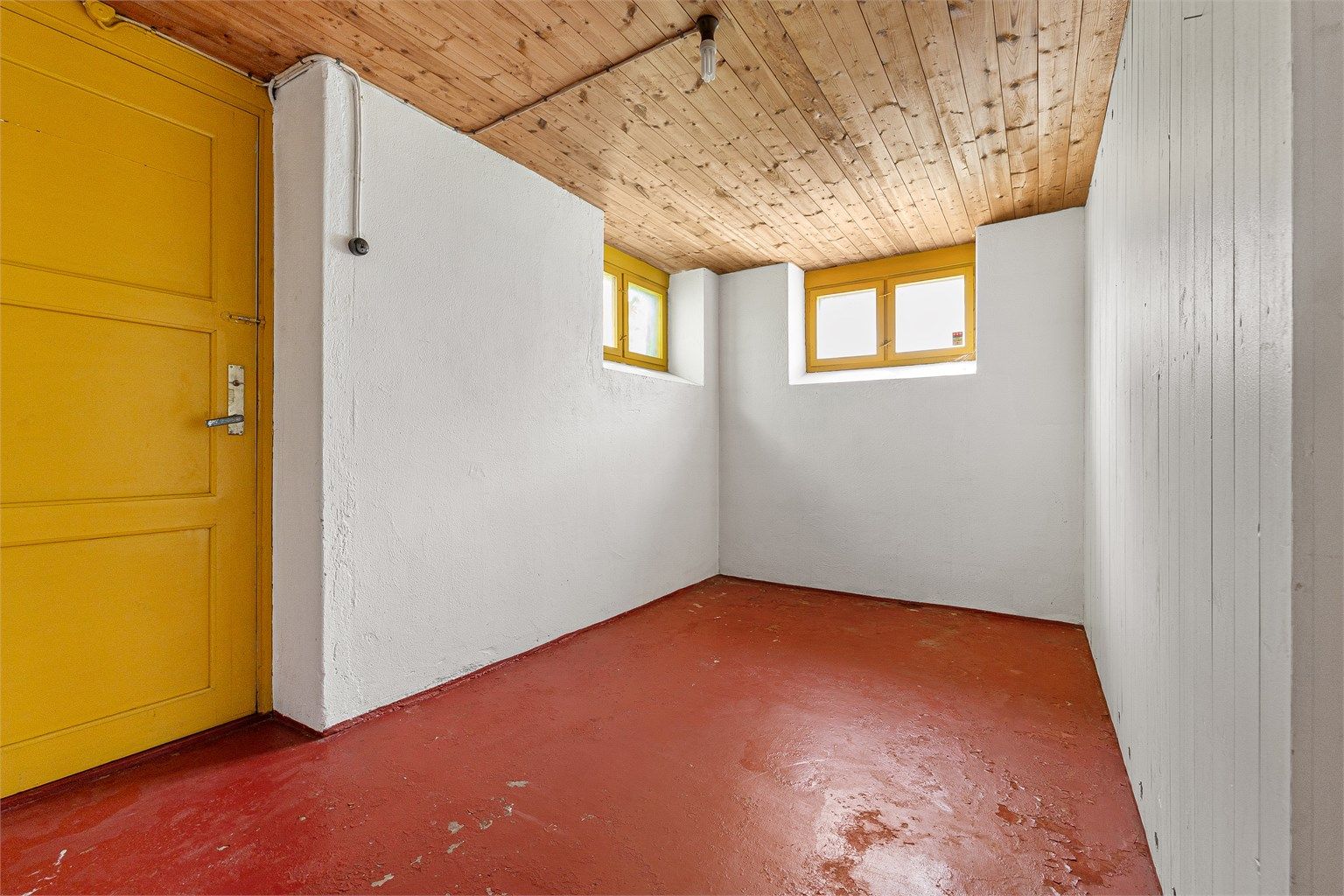 Bodene har overflater som malt betong og panelbord i himling.