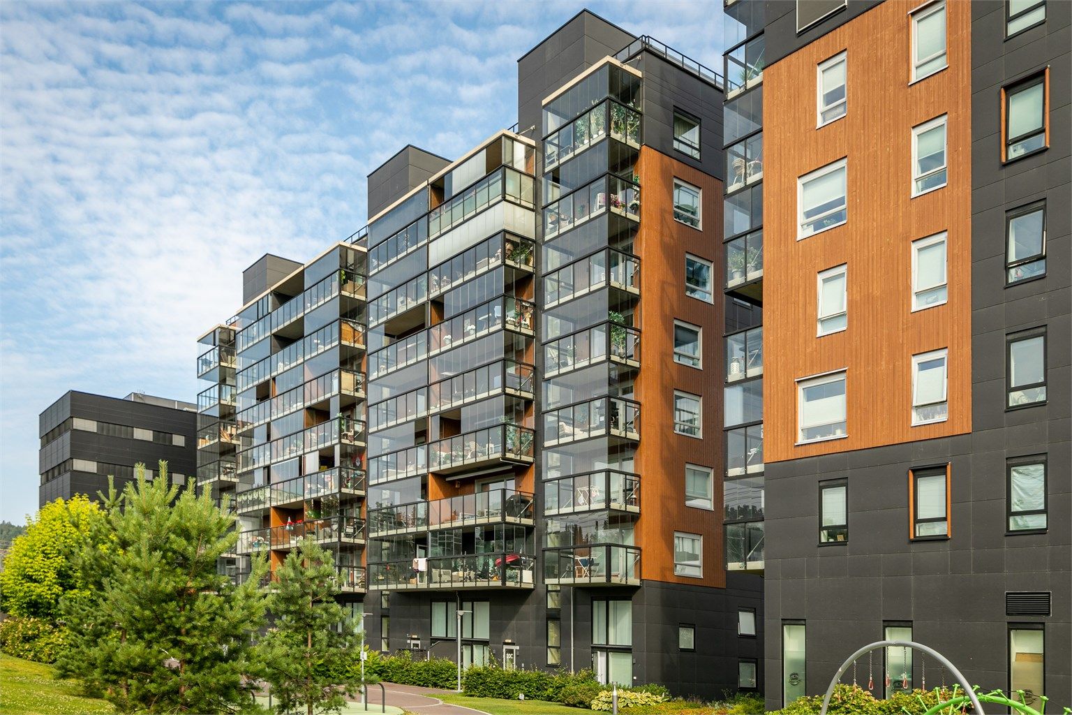 Moderne leilighetsbygg fra 2020 med fasader kledd i stående trekledning.