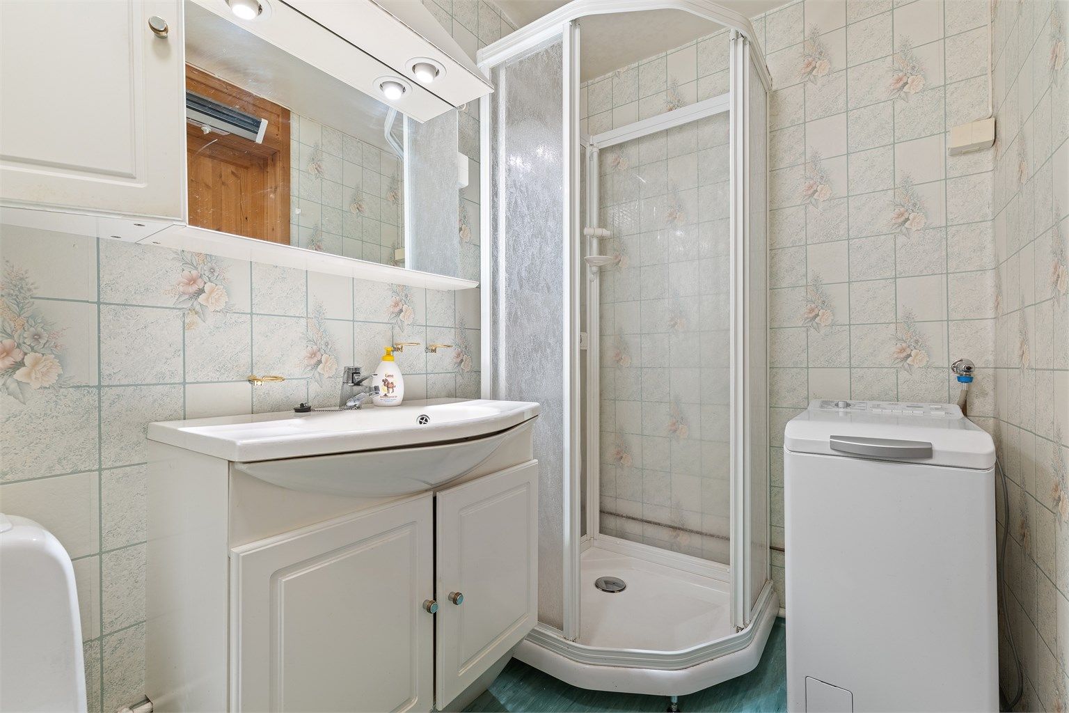 Badet er utstyrt med dusjkabinett og har opplegg for vaskemaskin.