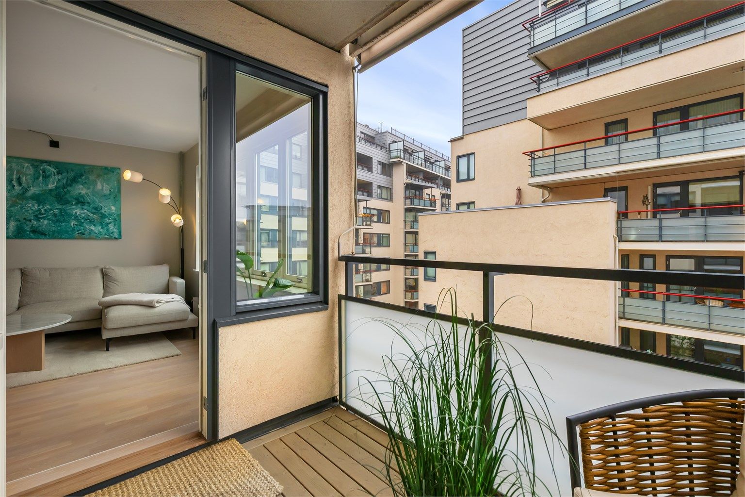 Gulvet er belagt med terrassebord, og rekkverket er i metall og glass.