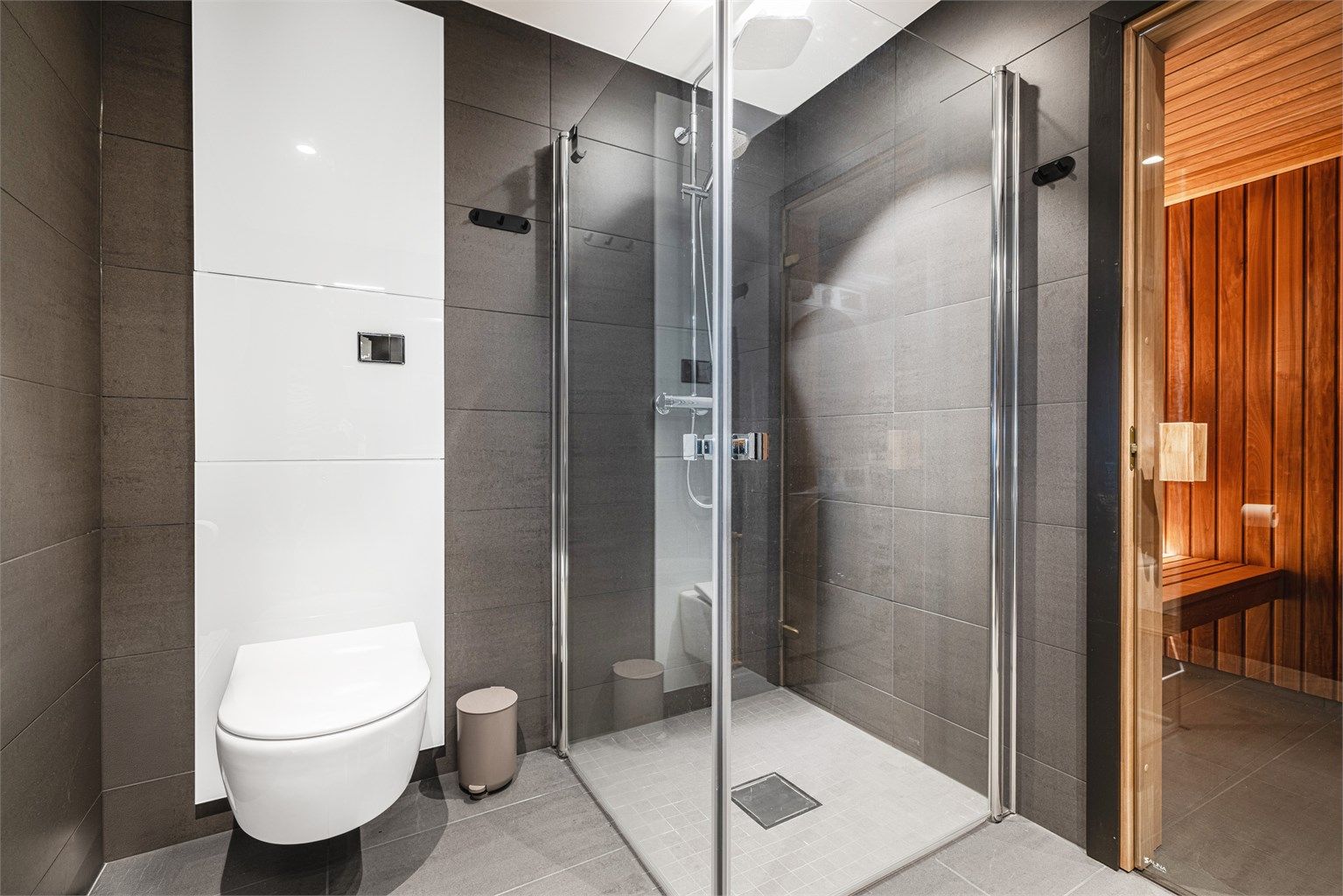 Badet er utstyrt med en romslig dusjnisje og vegghengt toalett med innebygget sisterne fra Tece.