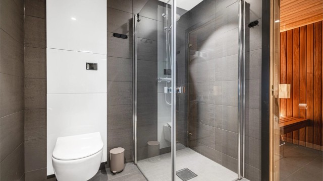 Badet er utstyrt med en romslig dusjnisje og vegghengt toalett med innebygget sisterne fra Tece.