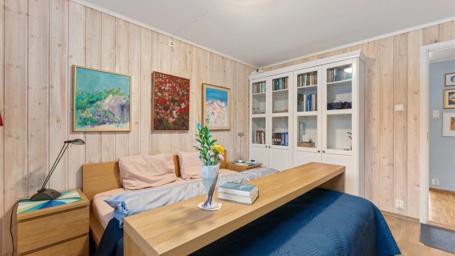 Rommet har en lun atmosfære med panel på veggene.