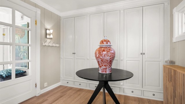 Romslig entré med rikelig med plassbygde garderobeskap. Doble glassdører mellom entréen og hallen