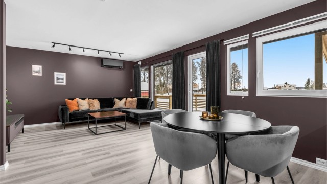 Romslig stue med store vindusflater som gir mye naturlig lys