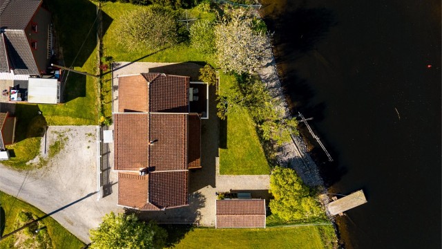 Tomten er tilnærmet flat og pent opparbeidet med plen og beplantning.