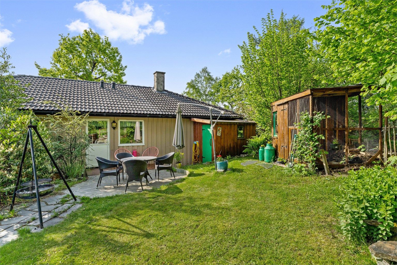 Hagen er pent opparbeidet med plen, platting og diverse beplantning.
