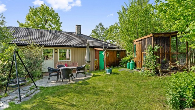 Hagen er pent opparbeidet med plen, platting og diverse beplantning.