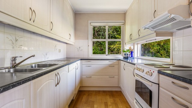Kjøkkeninnredning med profilerte fronter og benkeplate med laminert overflate. Det er god skap- og benkeplass.