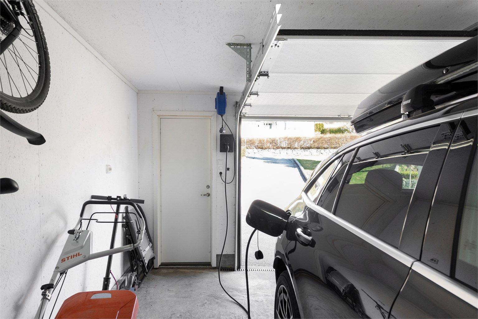 Garasjen er utstyrt med el-billader og har nyere metallport med portåpner