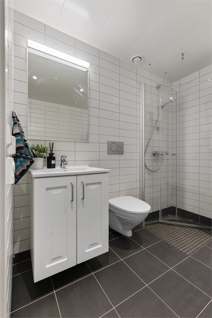 Baderomsinnredning med servant, speil og belysning.