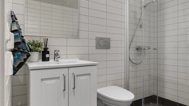 Baderomsinnredning med servant, speil og belysning.